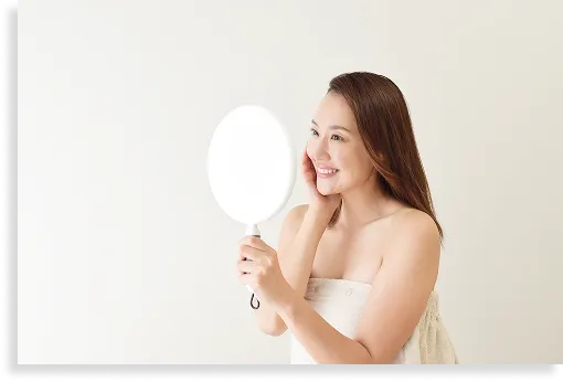 鏡を見て笑顔の女性